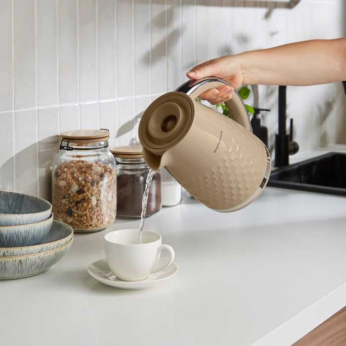 jug kettle filling up a tea cup on a kitchen counter