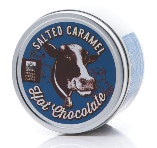 Tin of salted caramel hot chocolate with a cow illustration on a blue background